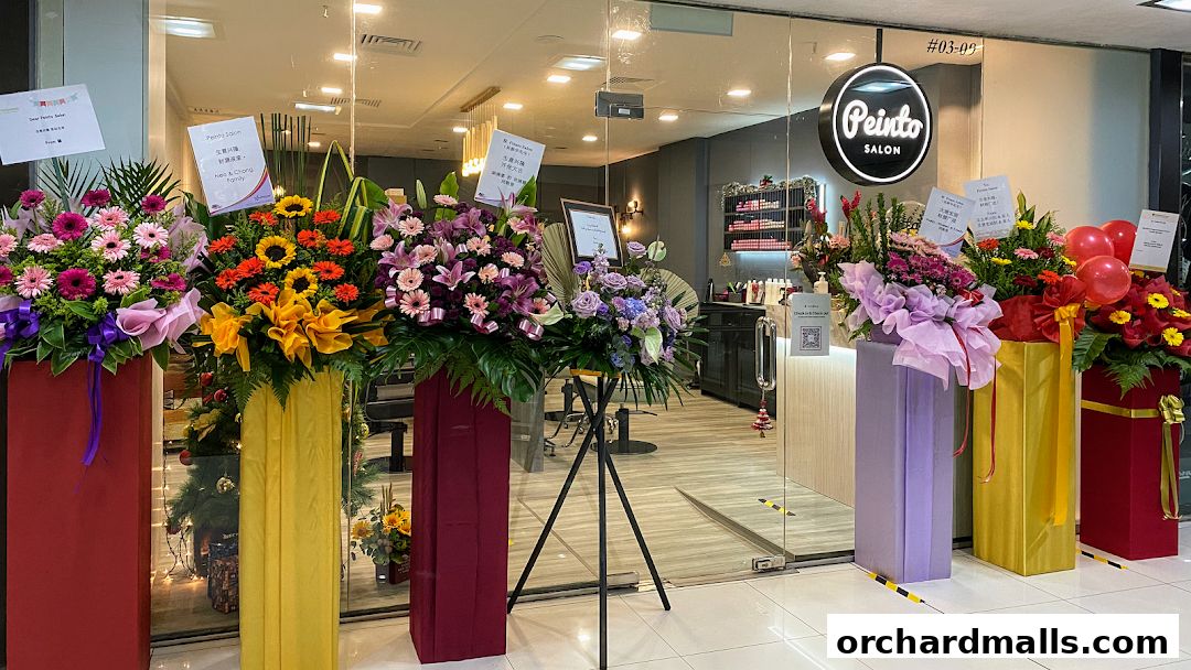 Peinto Salon storefront decorated with congratulatory flower stands and balloons.