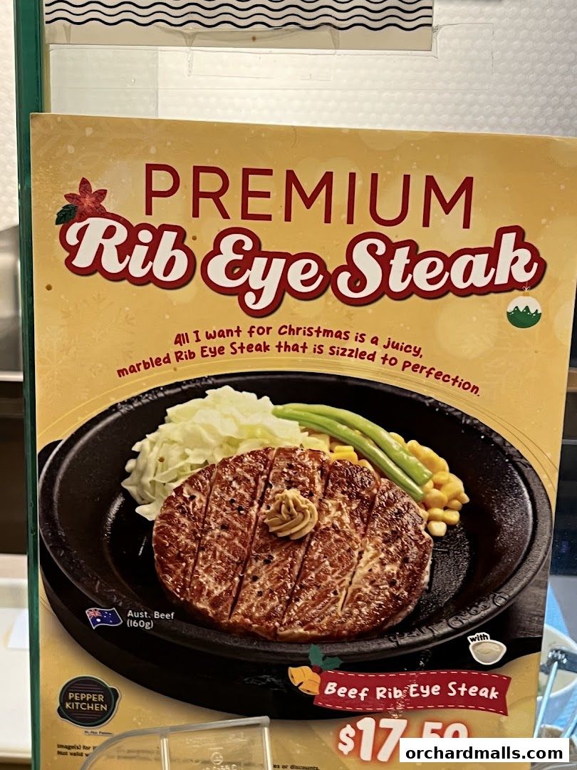 A close-up of a premium rib eye steak dish with sides and price.