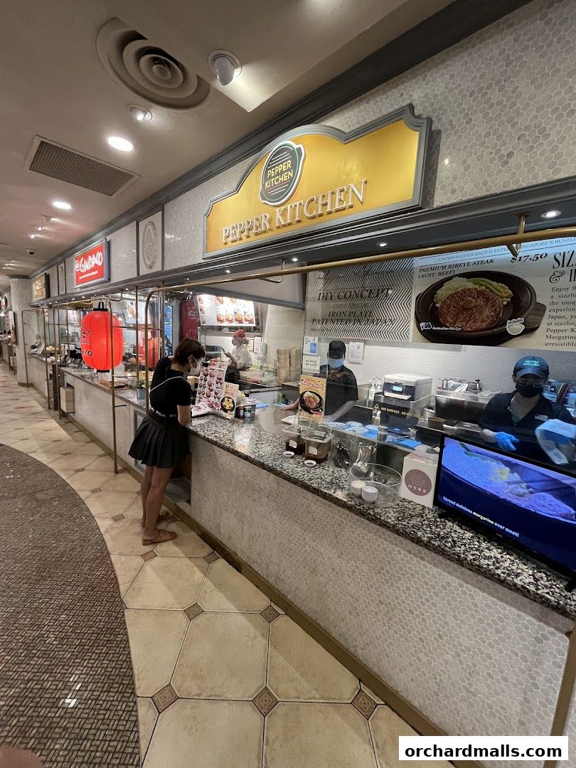 Pepper Kitchen shop counter with staff serving customers and a display of their signature steak.