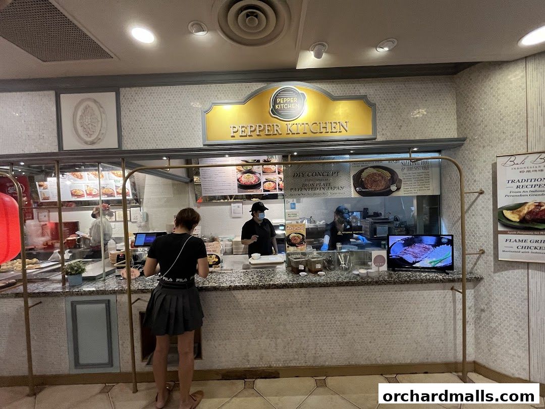 A view of the Pepper Kitchen counter with staff serving customers and menu displays.