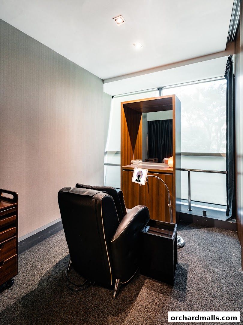 A comfortable black chair with a side table in a modern salon setting.