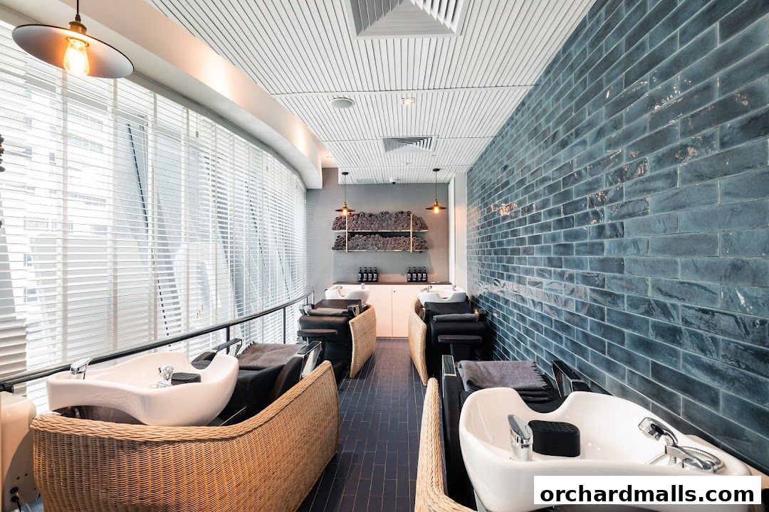 Interior view of a modern hair salon with wash stations and blue brick walls.