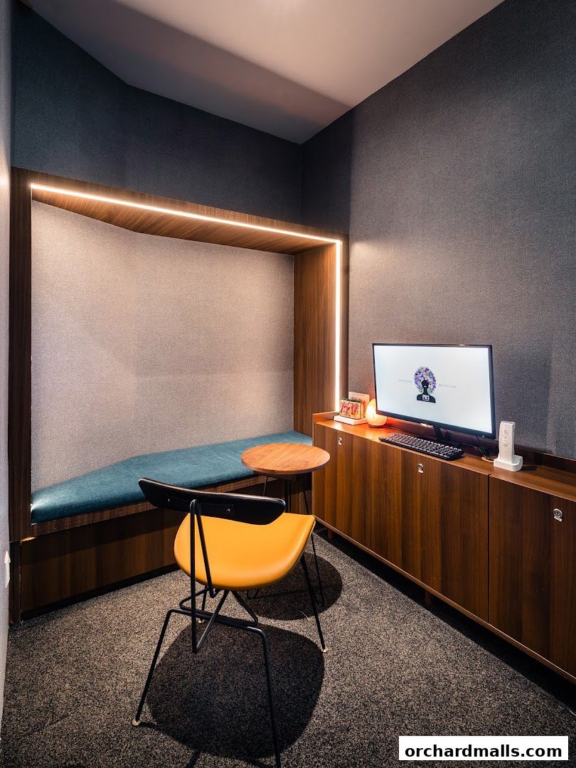 A modern consultation room with a comfortable bench, desk, and computer.