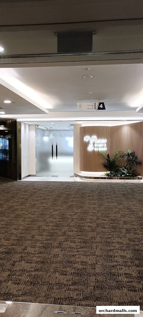 Entrance to Picasso Plastic Surgery Wheelock Place with frosted glass doors and neon signage.