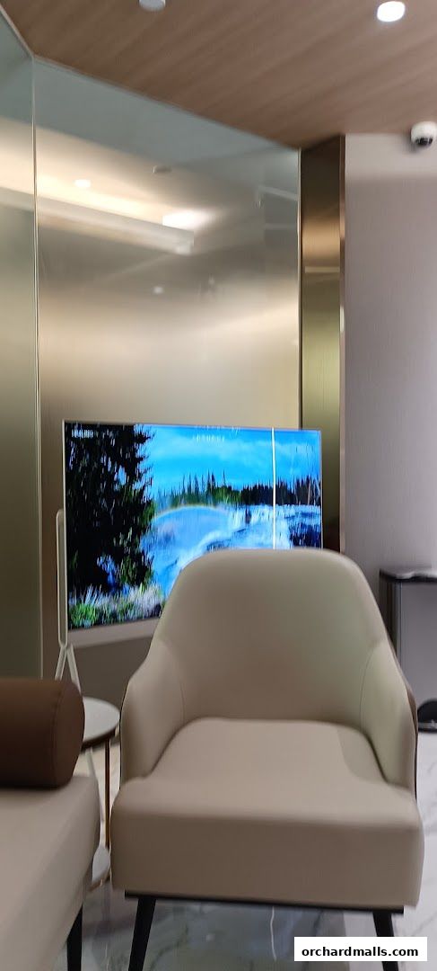 A waiting area with comfortable seating and a large screen displaying a scenic view.