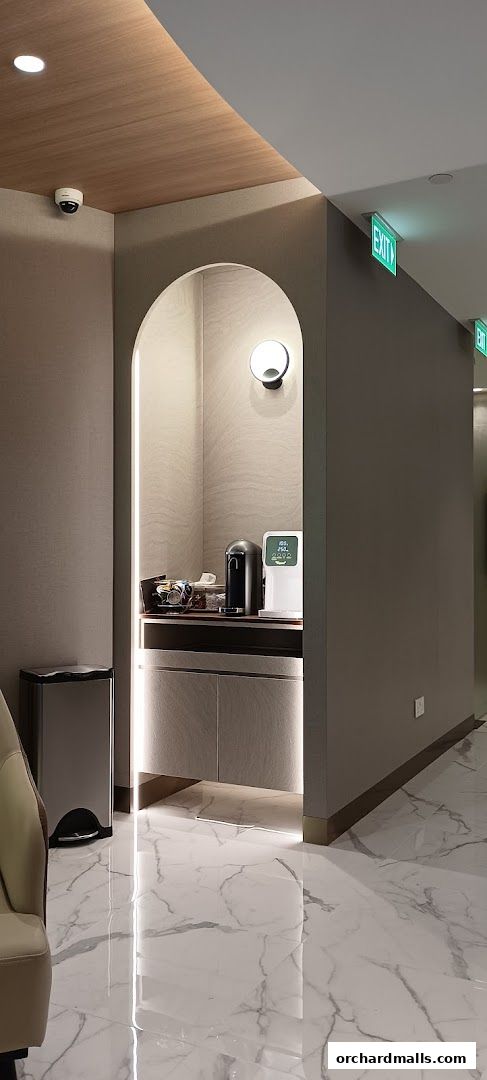 A modern waiting area with a beverage station and marble flooring.