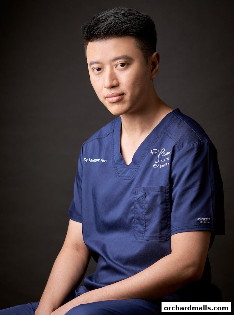 A portrait of Dr. Matthew Yeo in a navy blue scrub top with the Picasso Plastic Surgery logo.