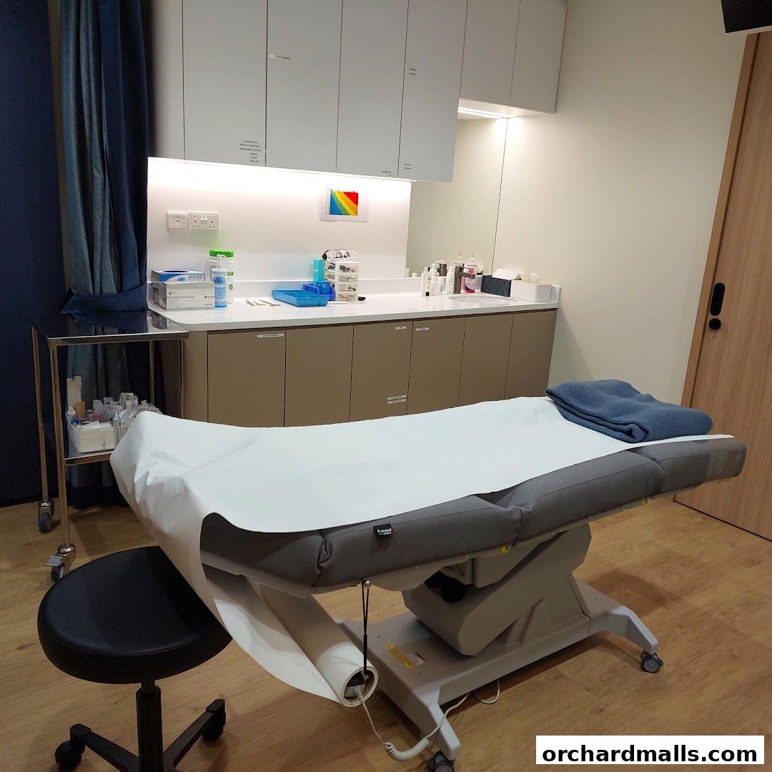 A clean and modern treatment room with a medical bed and supplies.