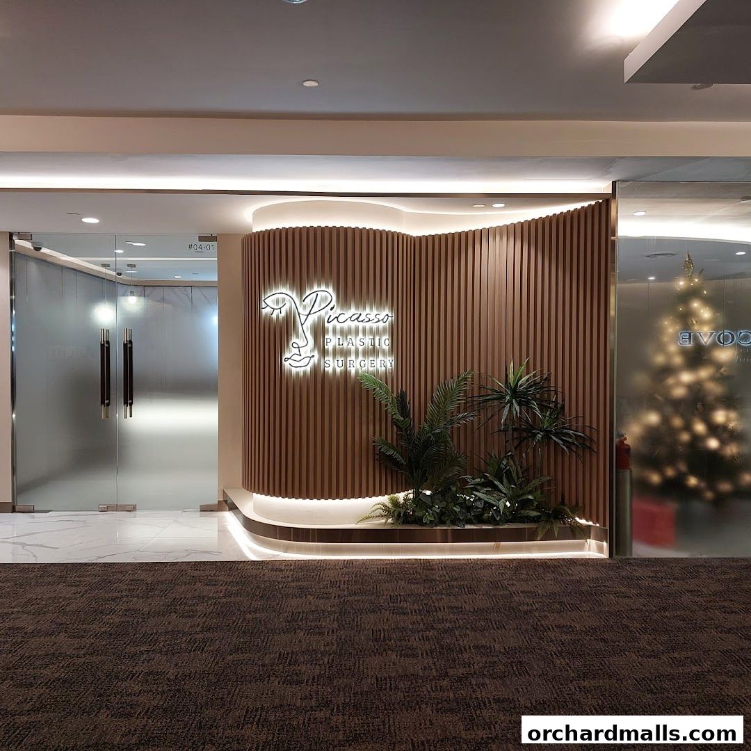 The entrance to Picasso Plastic Surgery with a modern wooden facade and illuminated logo.
