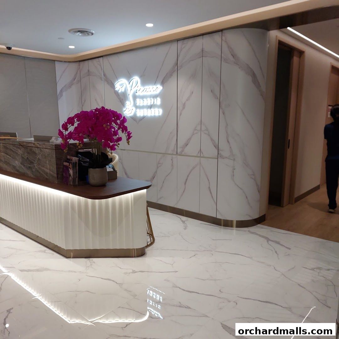 Elegant reception area of Picasso Plastic Surgery with marble accents and a neon sign.