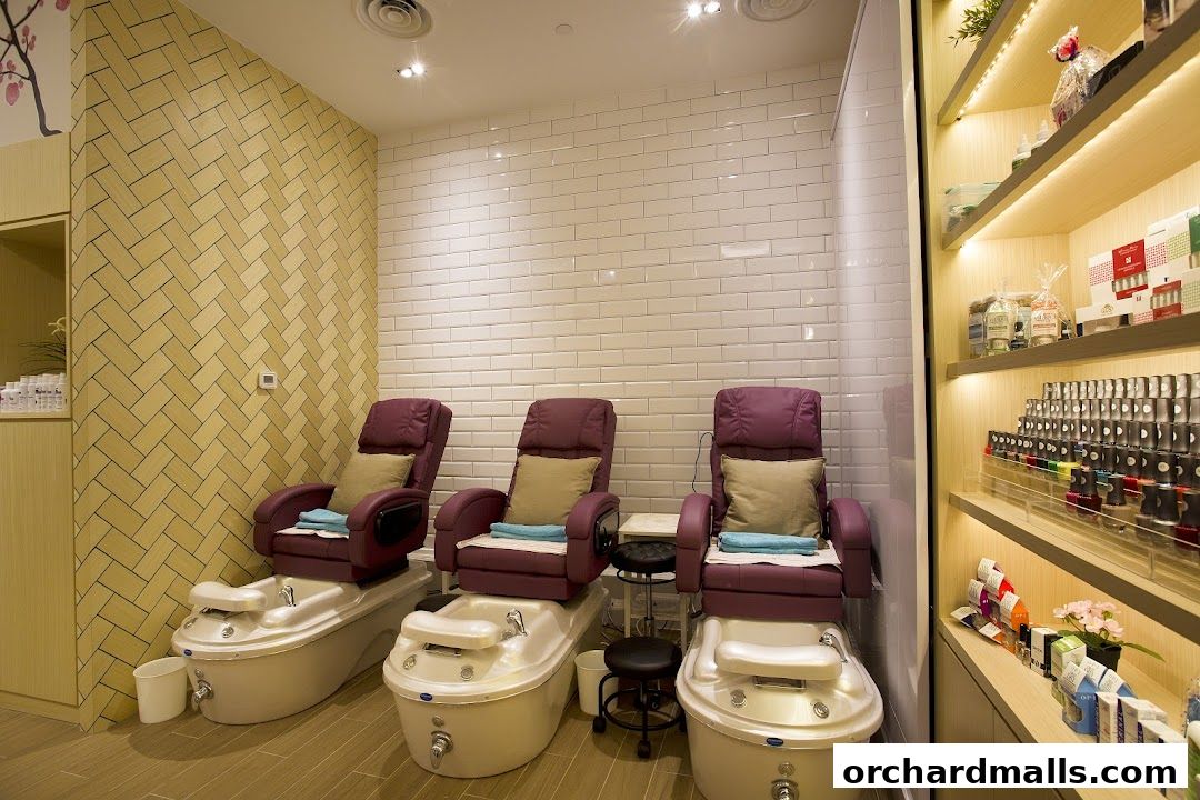 Interior view of a nail spa with pedicure chairs and shelves stocked with nail polish.