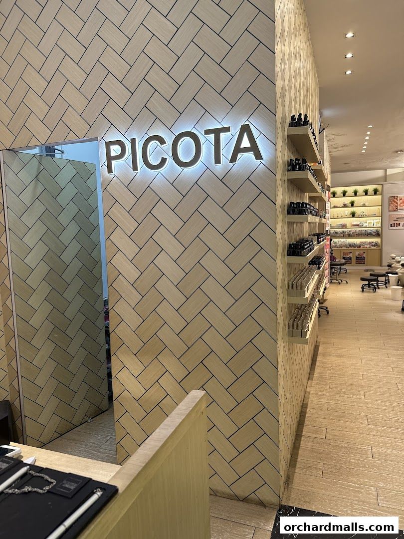 Interior view of Picota Nail Spa with illuminated signage and shelves stocked with nail polish.