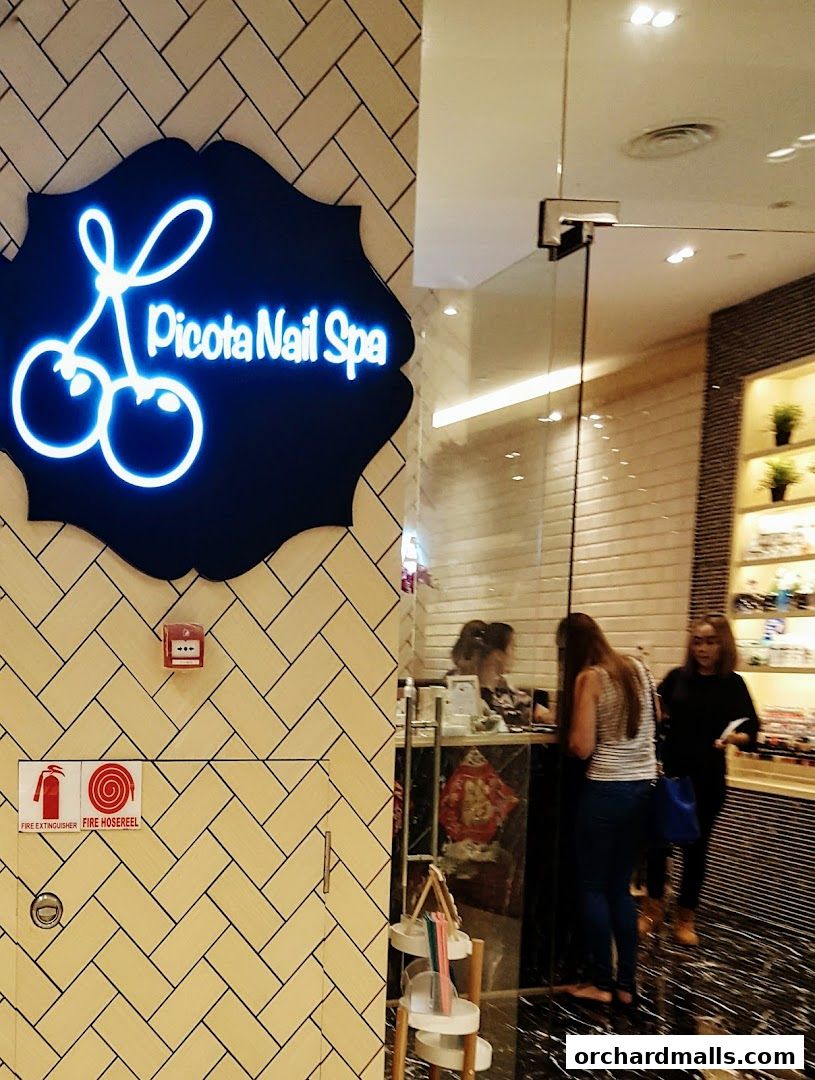 The entrance to Picota Nail Spa, featuring a neon sign and a glass door.