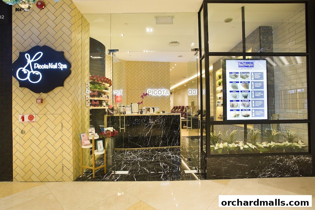 The entrance of Picota Nail Spa with a neon sign and a display of foot care products.