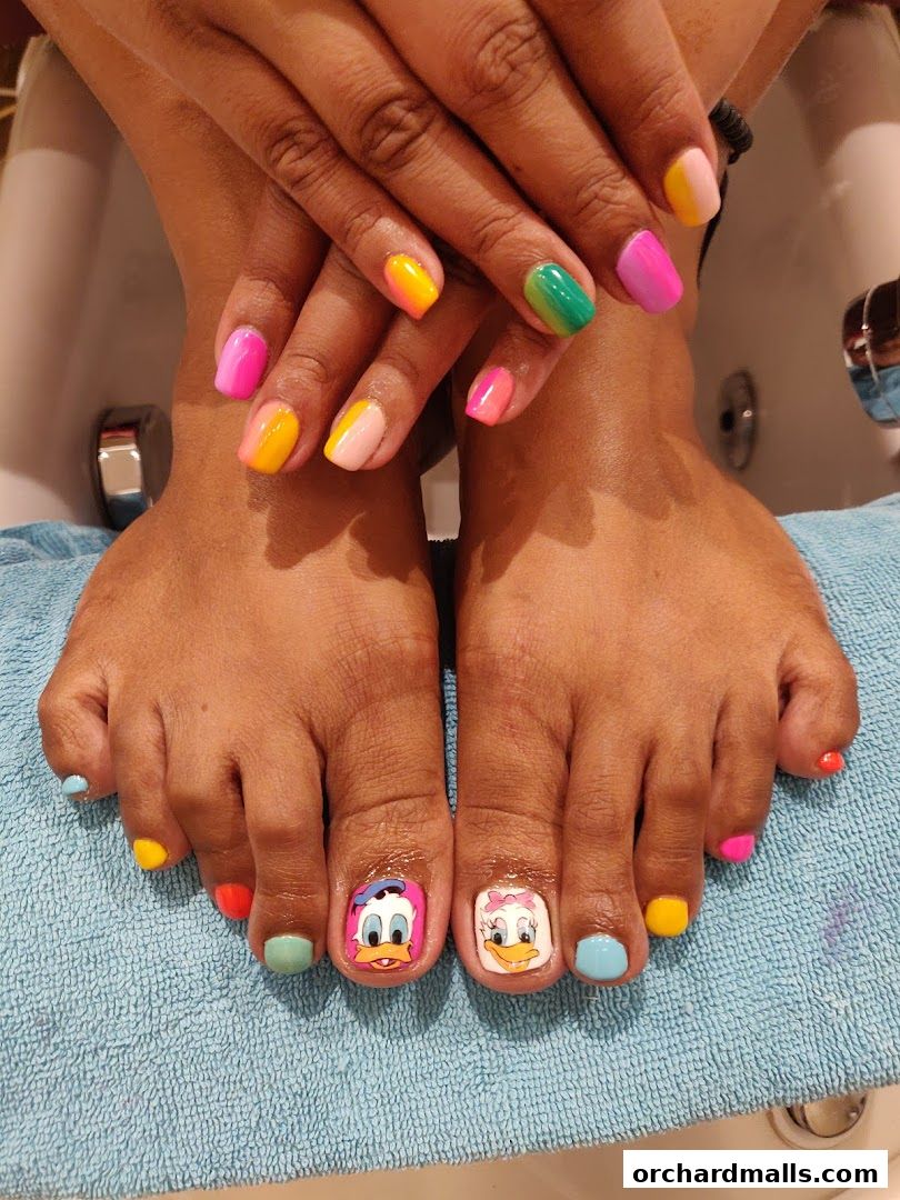 A person's hands and feet with colorful, cartoon-themed nail art.
