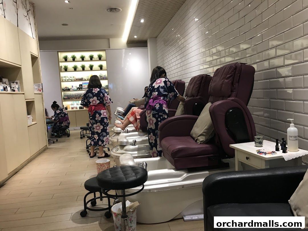 Interior of a nail spa with pedicure chairs and staff attending to clients.