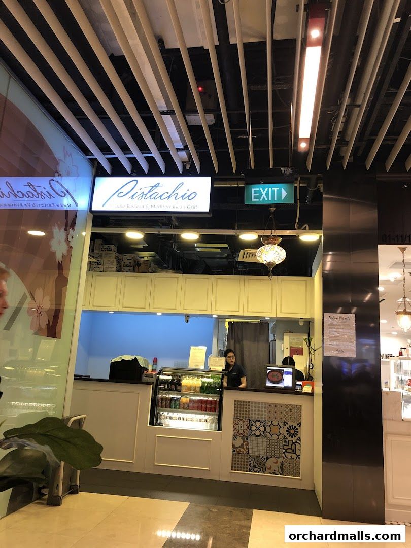 The exterior of Pistachio Middle Eastern & Mediterranean Grill with a counter and staff visible.
