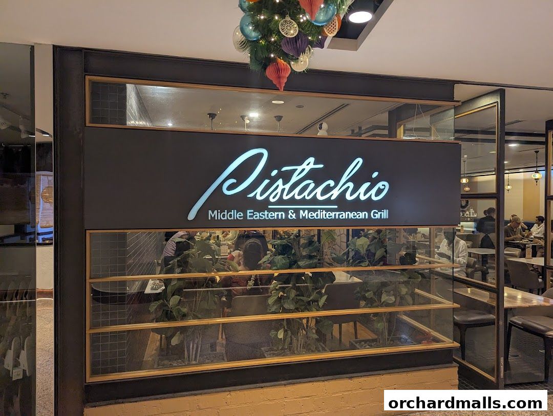 The exterior of Pistachio Middle Eastern & Mediterranean Grill with its illuminated sign.