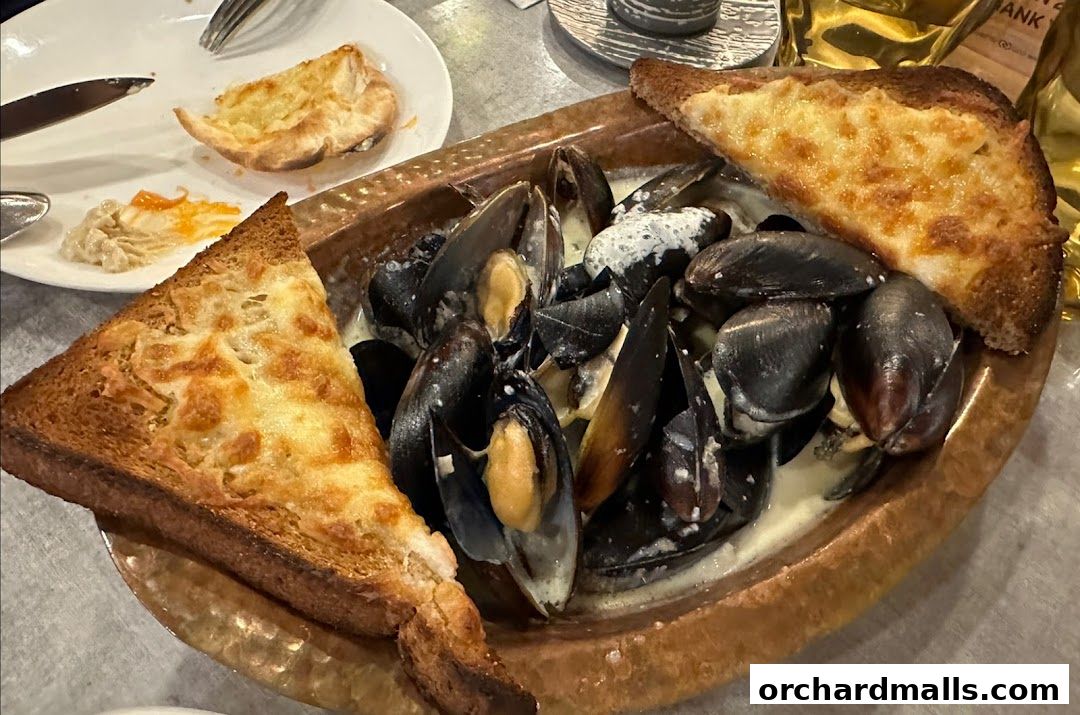 A close-up of a dish of mussels in a creamy sauce, served with cheesy toast.