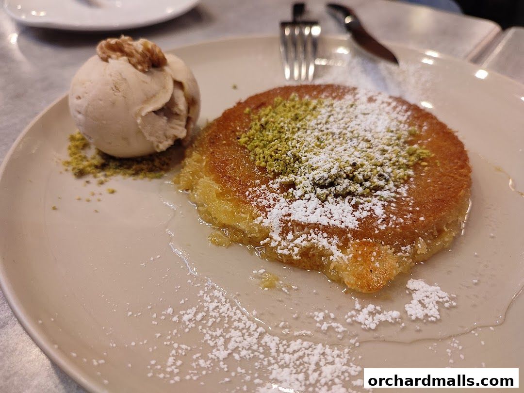 A delicious dessert with ice cream and nuts, dusted with powdered sugar.