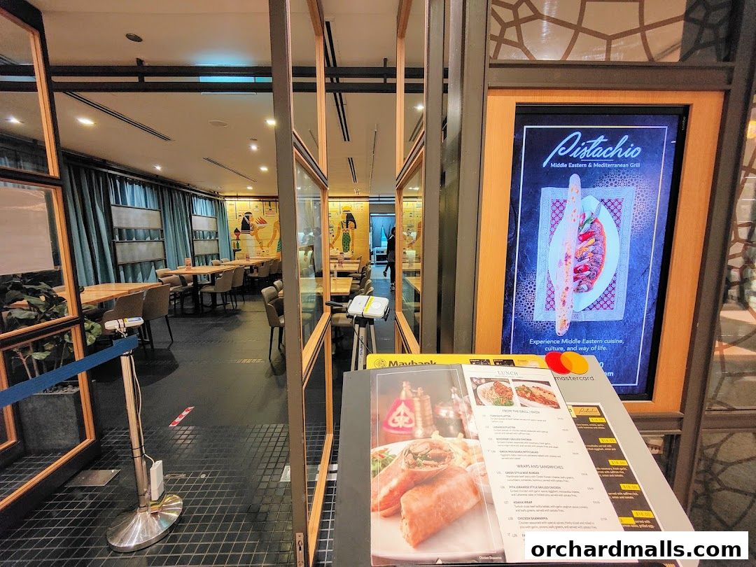 Entrance to Pistachio Middle Eastern Mediterranean Grill with a digital menu and a physical menu displayed.