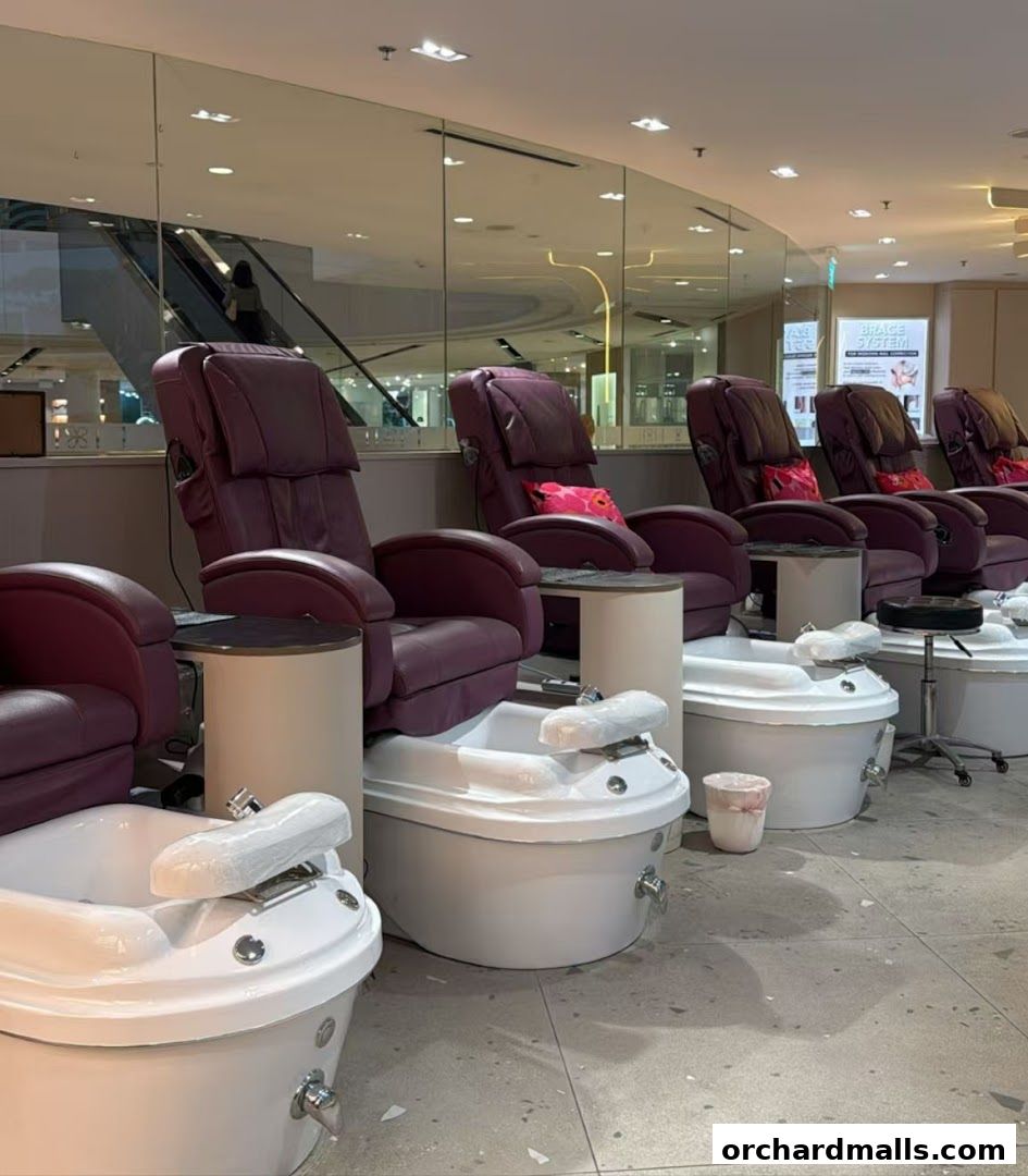 Plush pedicure chairs and foot baths are set up in a clean, modern nail spa.