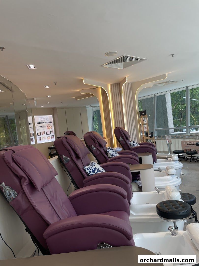 Plush purple pedicure chairs with built-in foot baths in a modern nail spa.