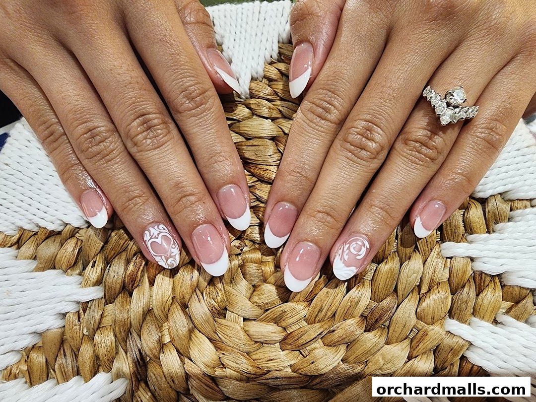 Close-up of hands with elegant French manicured nails featuring white nail art.