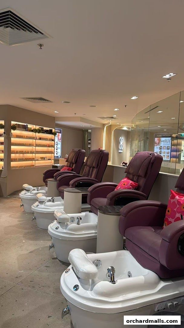 Luxurious pedicure chairs and foot baths are arranged in a clean, modern nail spa.