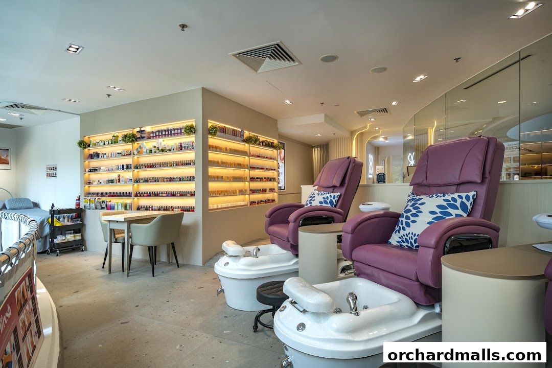 Interior of a nail spa with pedicure chairs, nail polish shelves, and a treatment bed.