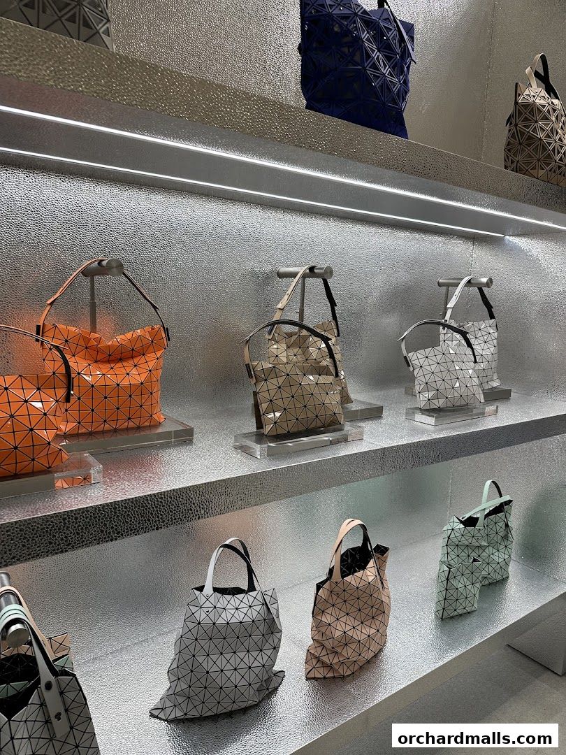 A display of geometric, pleated bags in various colors on silver shelves.