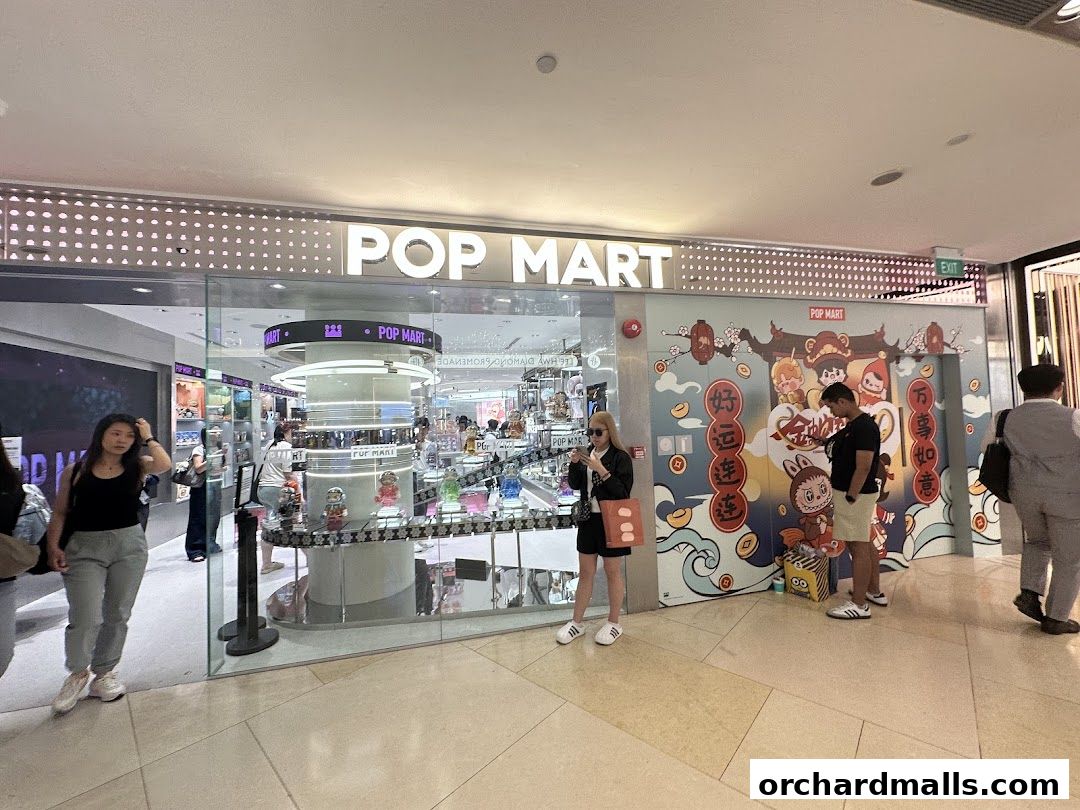 The POP MART store entrance with colorful decorations and people browsing inside.
