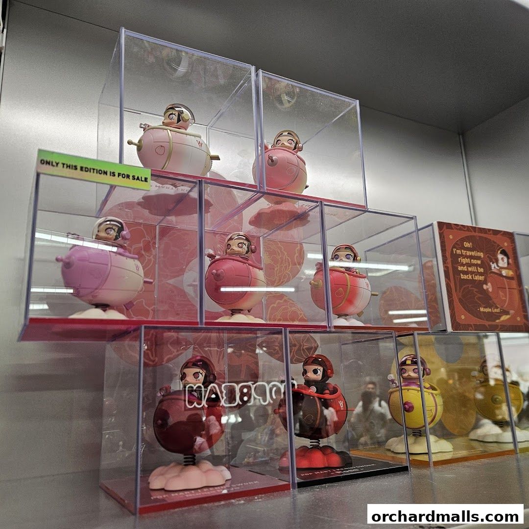 Display of collectible figures in clear cases, with a sign indicating limited availability.