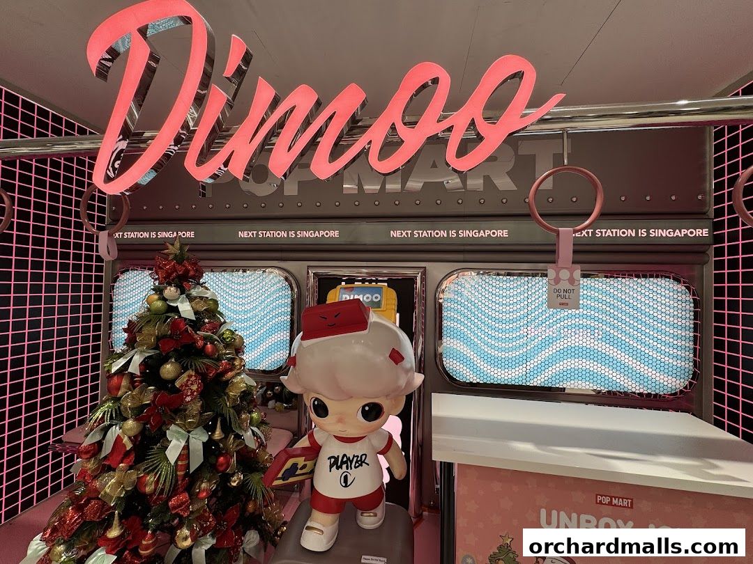 A POP MART store display featuring a Dimoo character, Christmas tree, and train-themed decor.