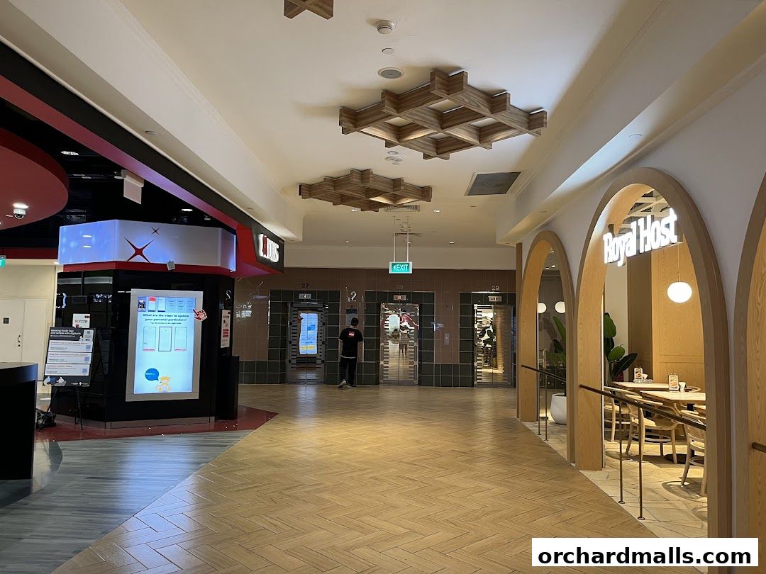 A mall corridor with shops, elevators, and a restaurant entrance.