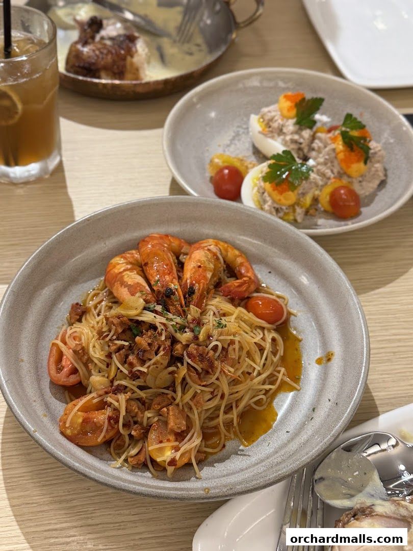 A close-up of a table with delicious pasta, deviled eggs, and a drink.
