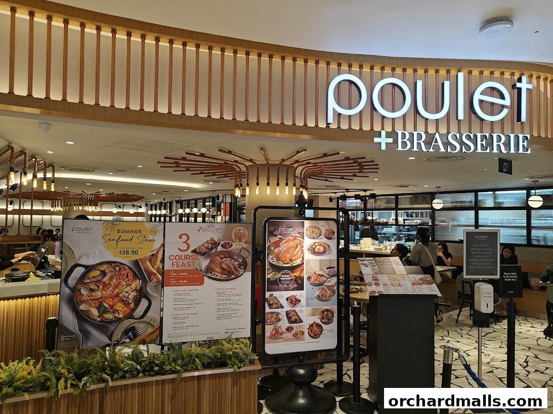 The exterior of Poulet + Brasserie restaurant with promotional posters and seating visible inside.
