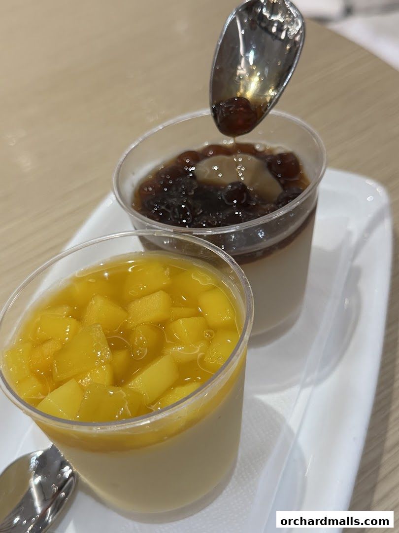 Two delicious desserts, one with mango and the other with tapioca pearls, served on a white tray.