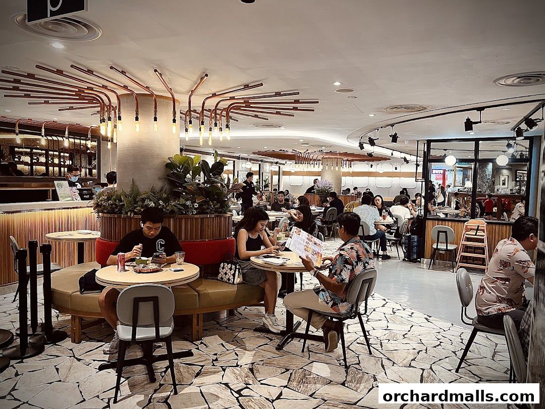 People dining at tables inside a modern restaurant with unique lighting fixtures.