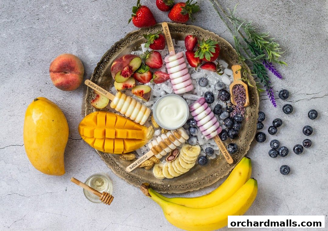 A refreshing assortment of fruit popsicles, fresh fruits, and yogurt on a decorative platter.