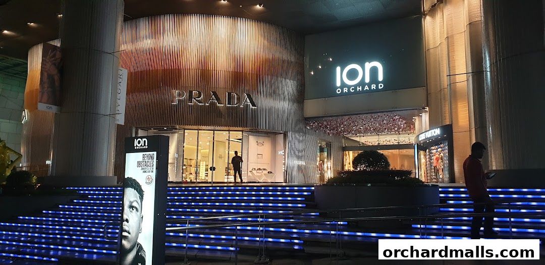 The illuminated entrance of the Prada store at ION Orchard, Singapore, at night.