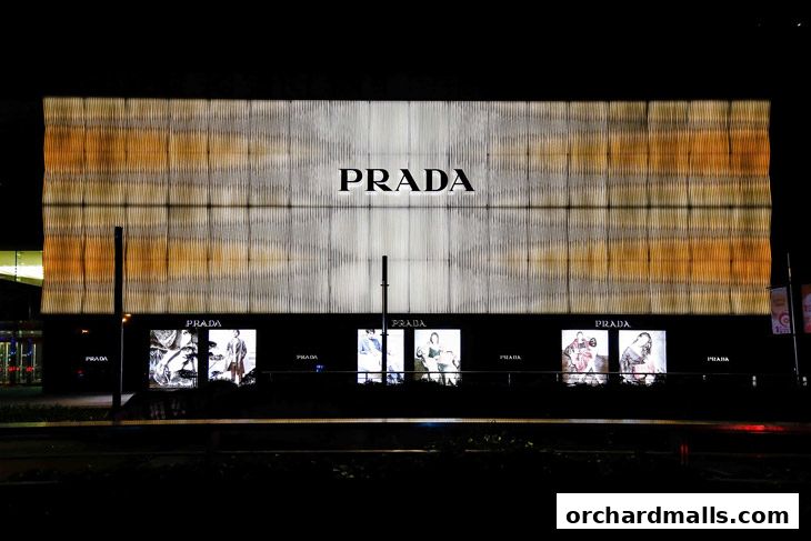 The illuminated Prada storefront at night, featuring the brand logo and display windows.