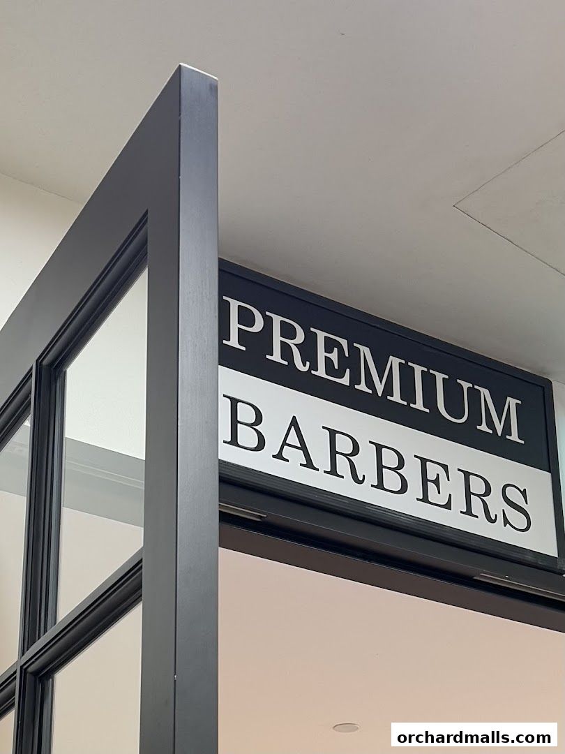 A sign for 'Premium Barbers' is visible above a doorway with a black frame.