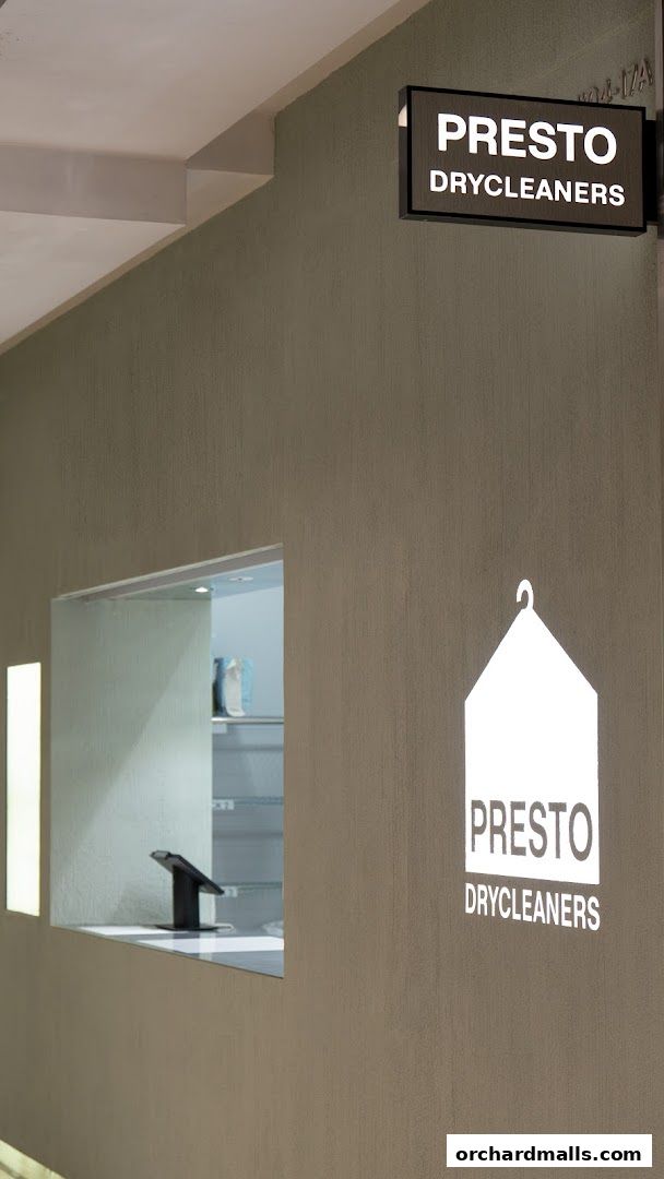 The exterior of Presto Drycleaners with its illuminated sign and logo.
