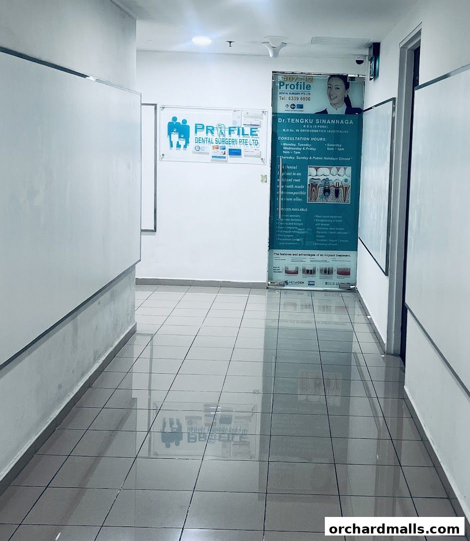 Entrance hallway of Profile Dental Surgery Pte Ltd with informational posters.