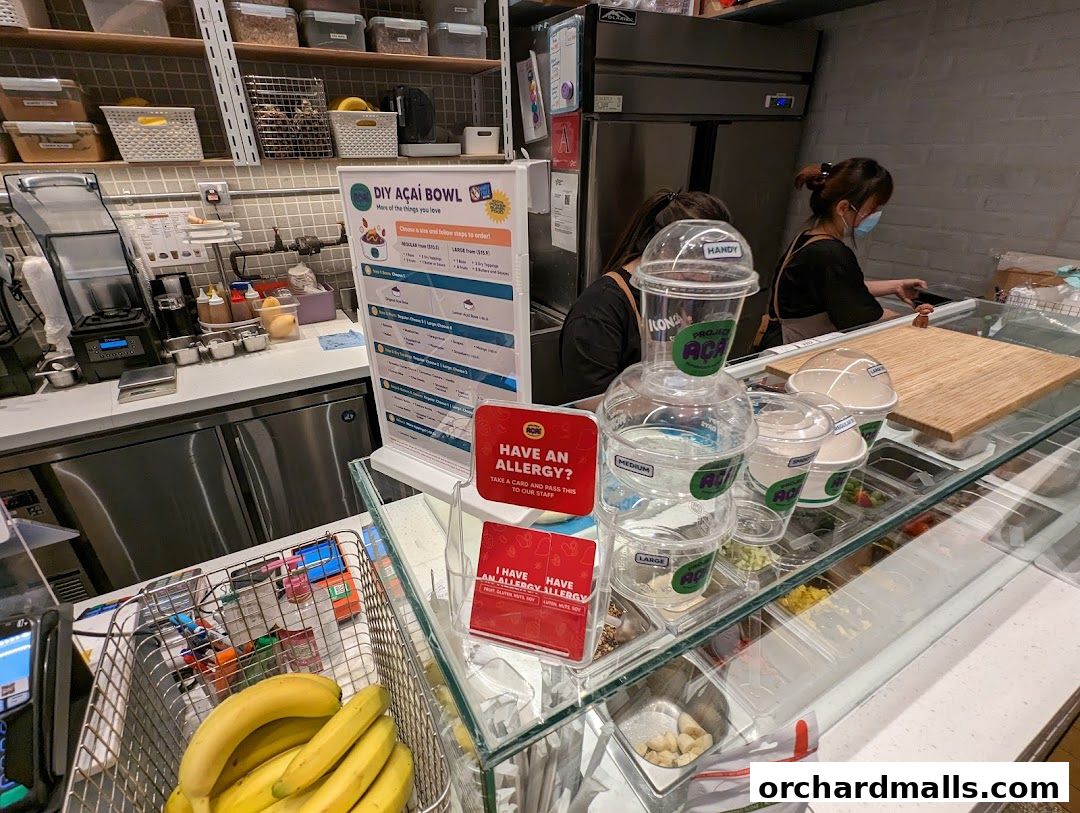 Açaí bowl shop counter with staff, ingredients, and a DIY bowl menu.