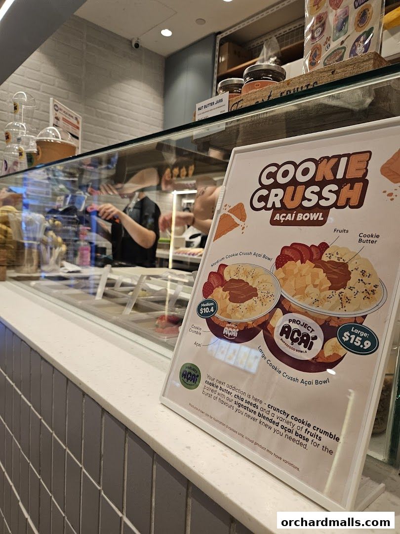 A sign displays the 'Cookie Crussh Açaí Bowl' with prices and ingredients.