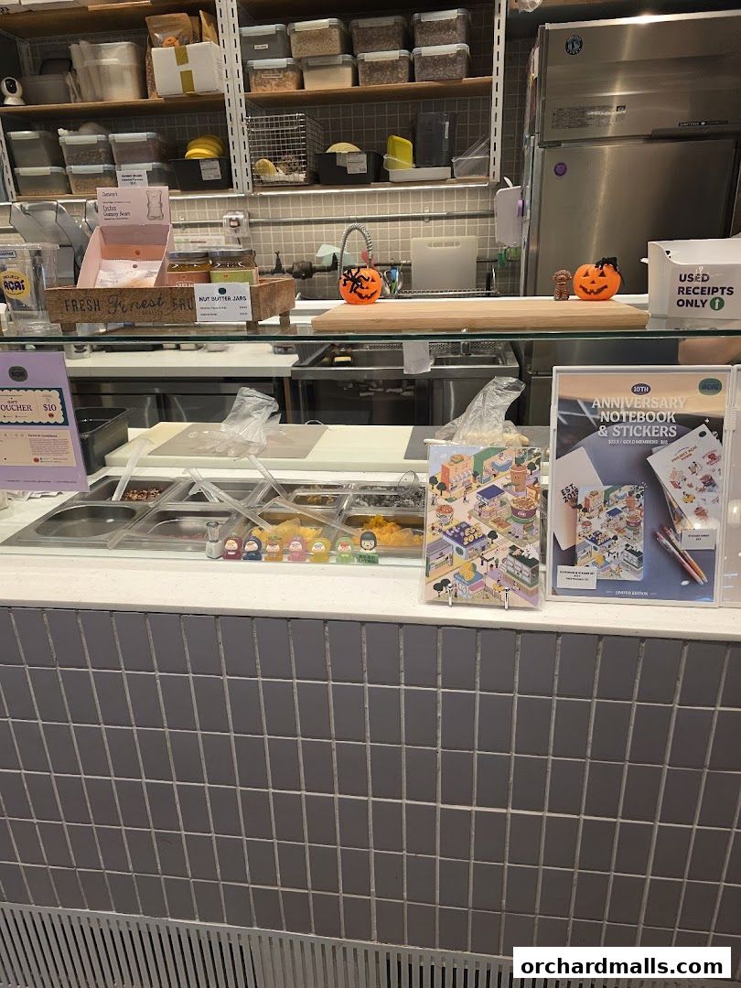 A counter display at Project Acai Ngee Ann City with ingredients and promotional items.