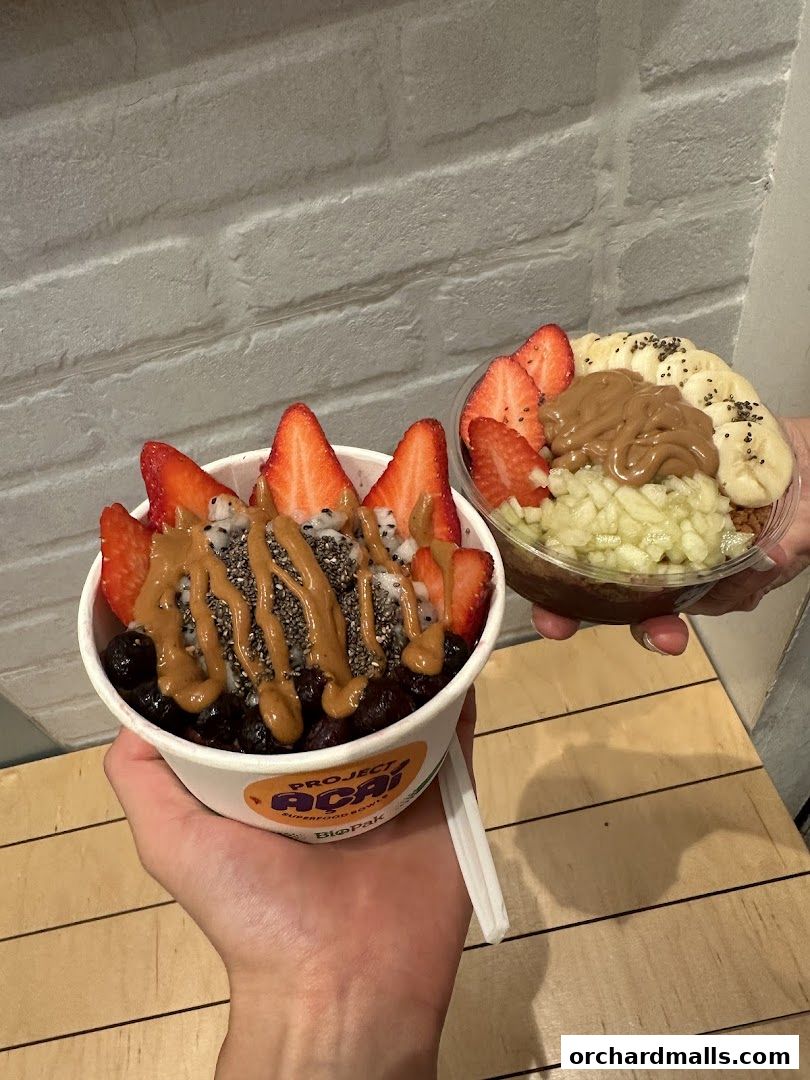 Two delicious acai bowls topped with fresh fruits and nut butter.