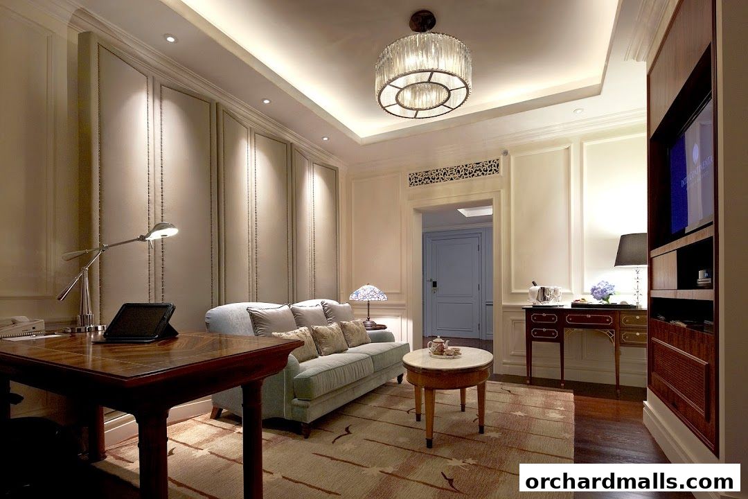 A luxurious hotel suite living area with a sofa, desk, and elegant decor.